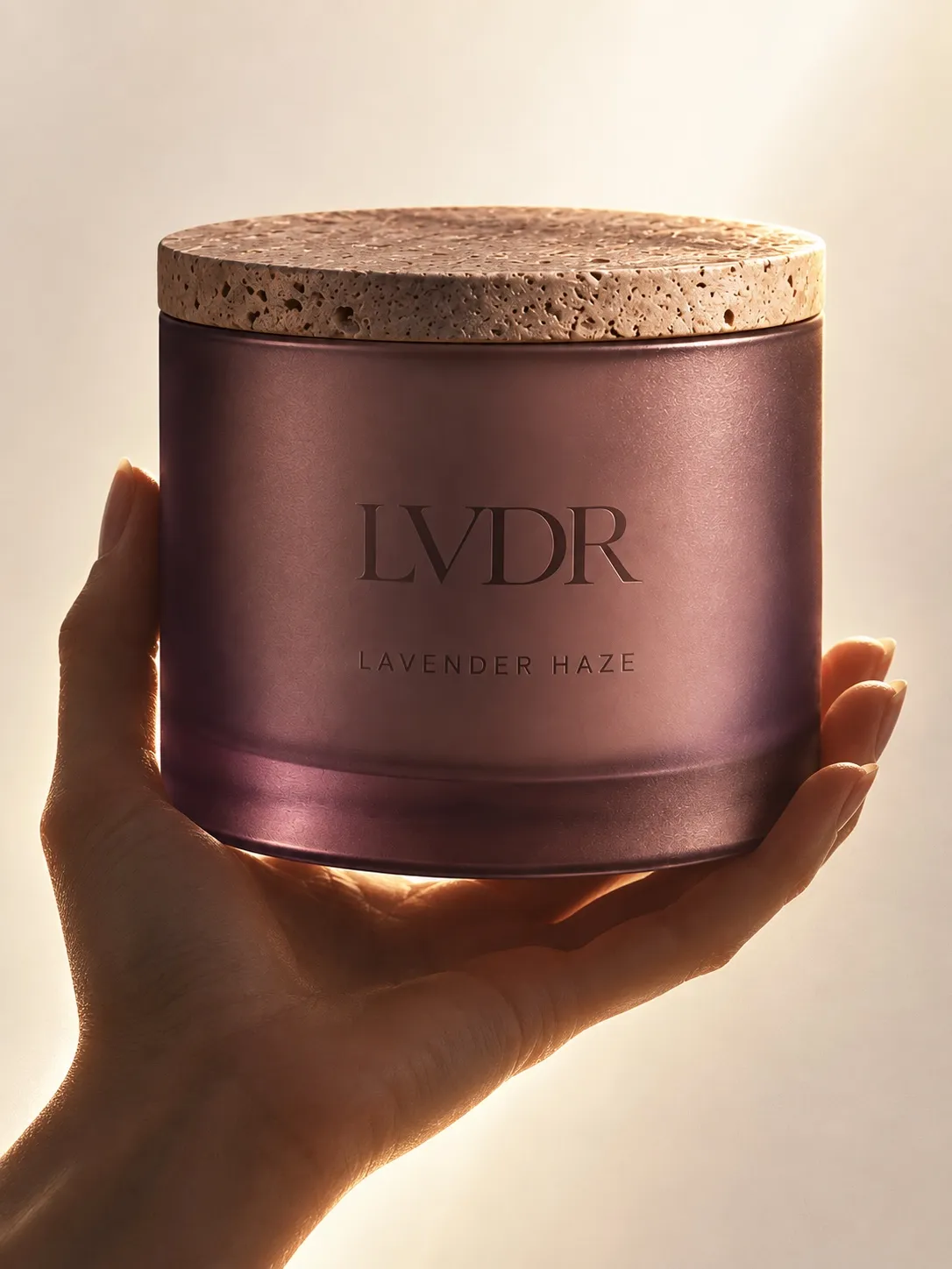 The Lavender Haze candle held up to the light